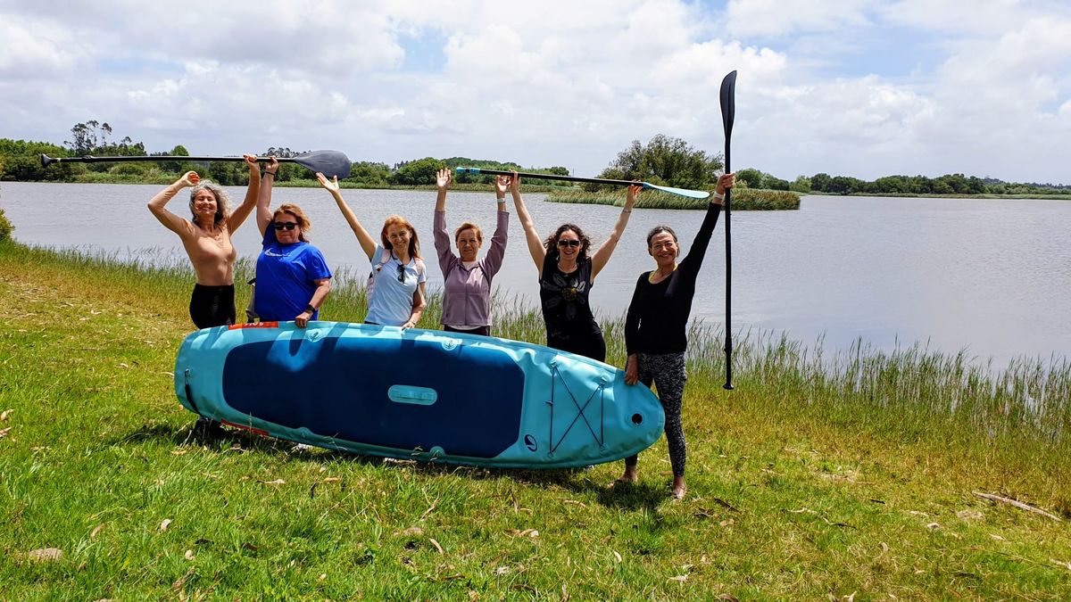 Grupo com uma prancha de stand up paddle junto à lagoa